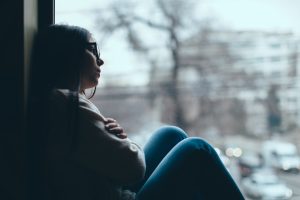 girl looking sad out window